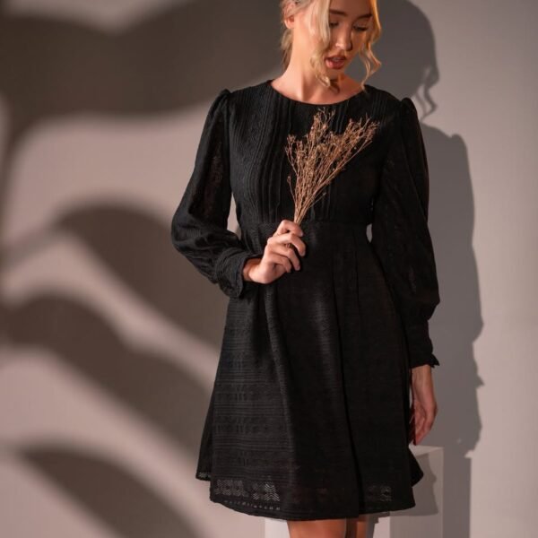 Black short dress with a round neckline, long sleeves and a geometric patterned texture.