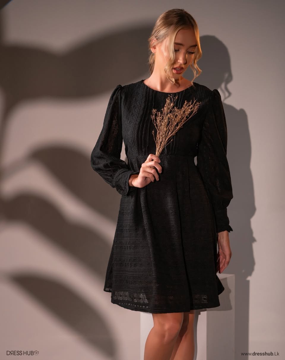 Black short dress with a round neckline, long sleeves and a geometric patterned texture.