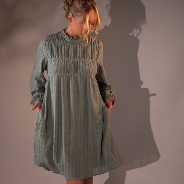 Sage-toned short dress with a high neckline, long sleeves and a geometric patterned texture.